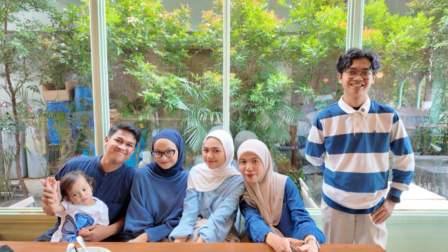 Tim RumaKerja berfoto bersama di sebuah kafe